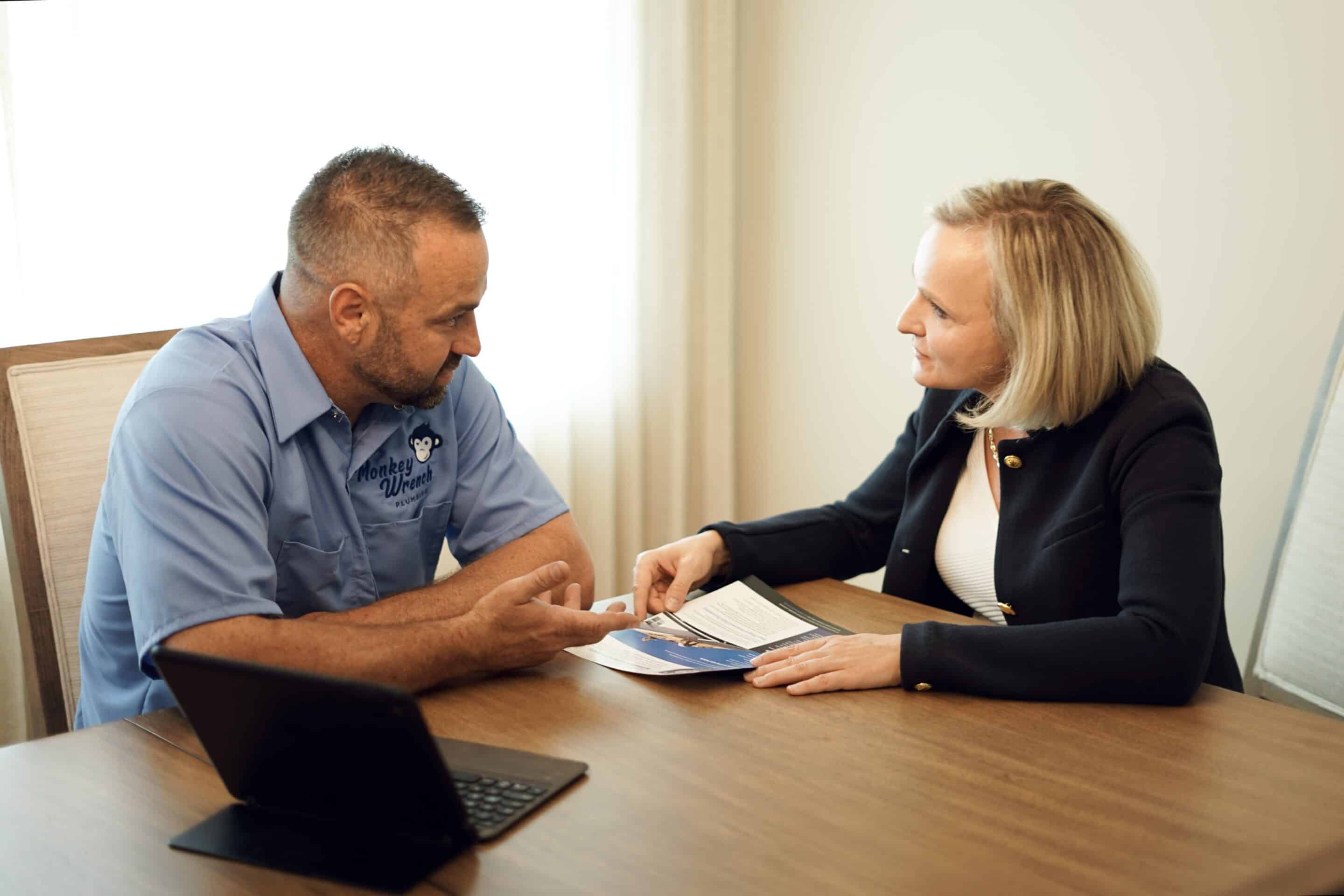 Plumber with a Pamphlet Talking to a Client | Best Plumbers in Midvale | Professional Plumbing Services in Utah