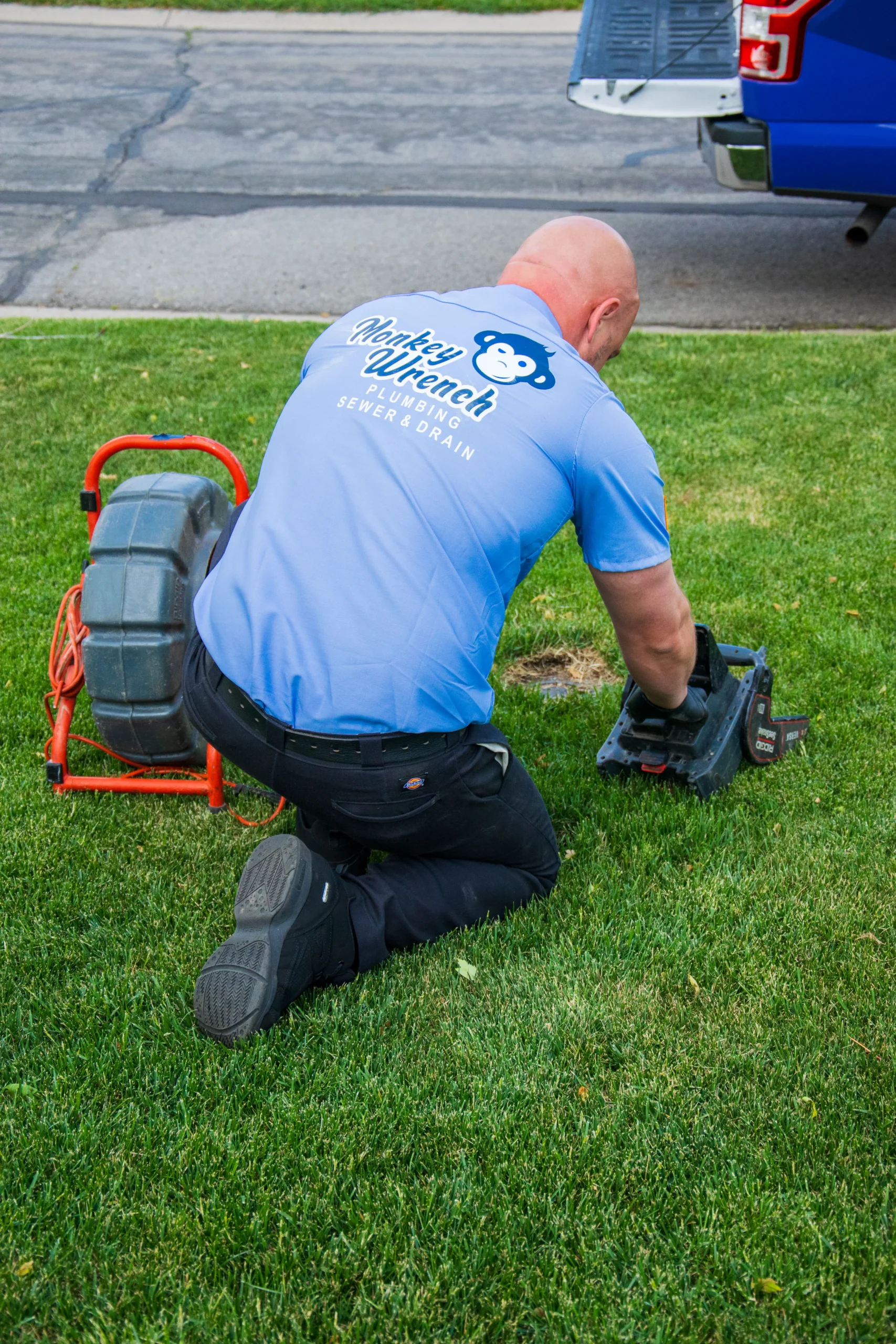 Plumber using tools to clean a drain, illustrating the process of preventing blockages and maintaining plumbing systems