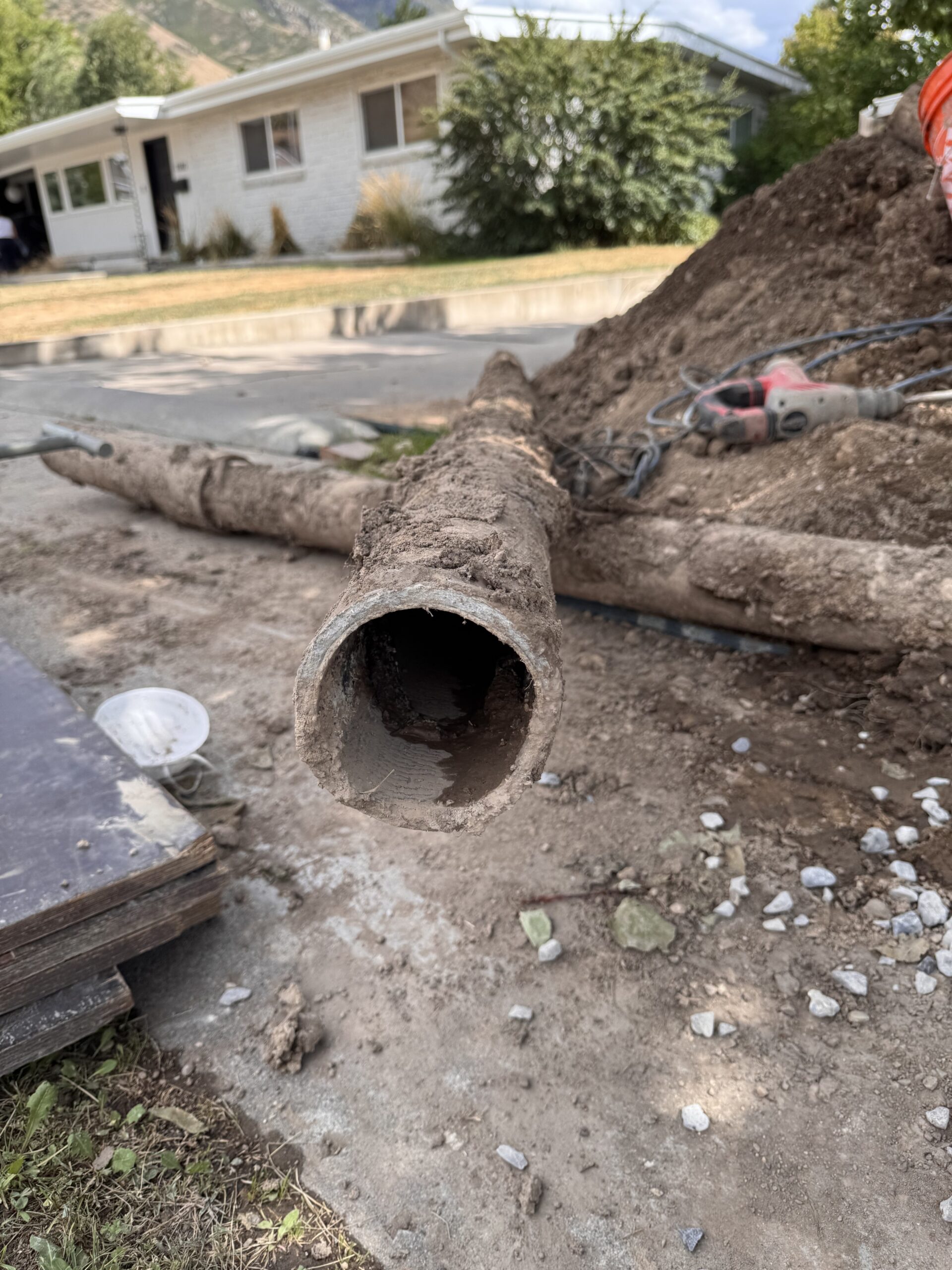 Cross section of the failed original sewer pipe removed from a Provo home showing heavy interior buildup